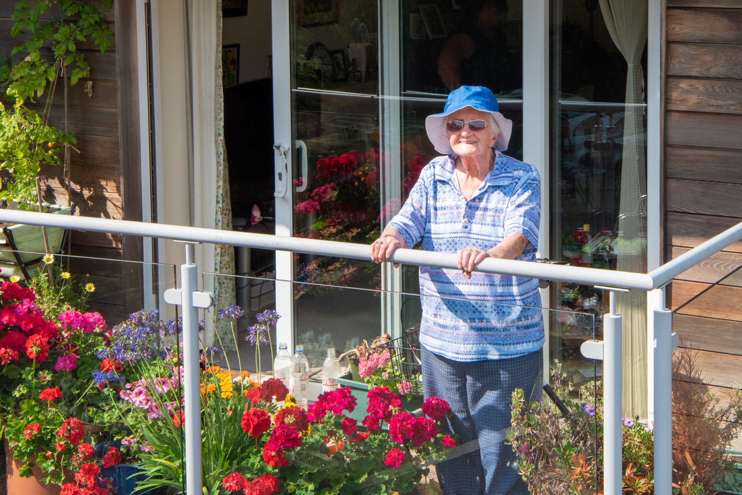 Knightwood resident stood on balcony amongst flowers
